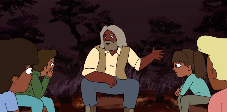 An Indigenous elder speaking to children in front of a camp fire.